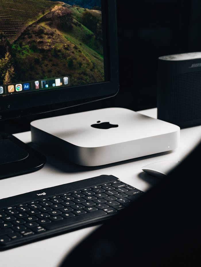 A sleek and modern workspace featuring a desktop computer, keyboard, and speaker.